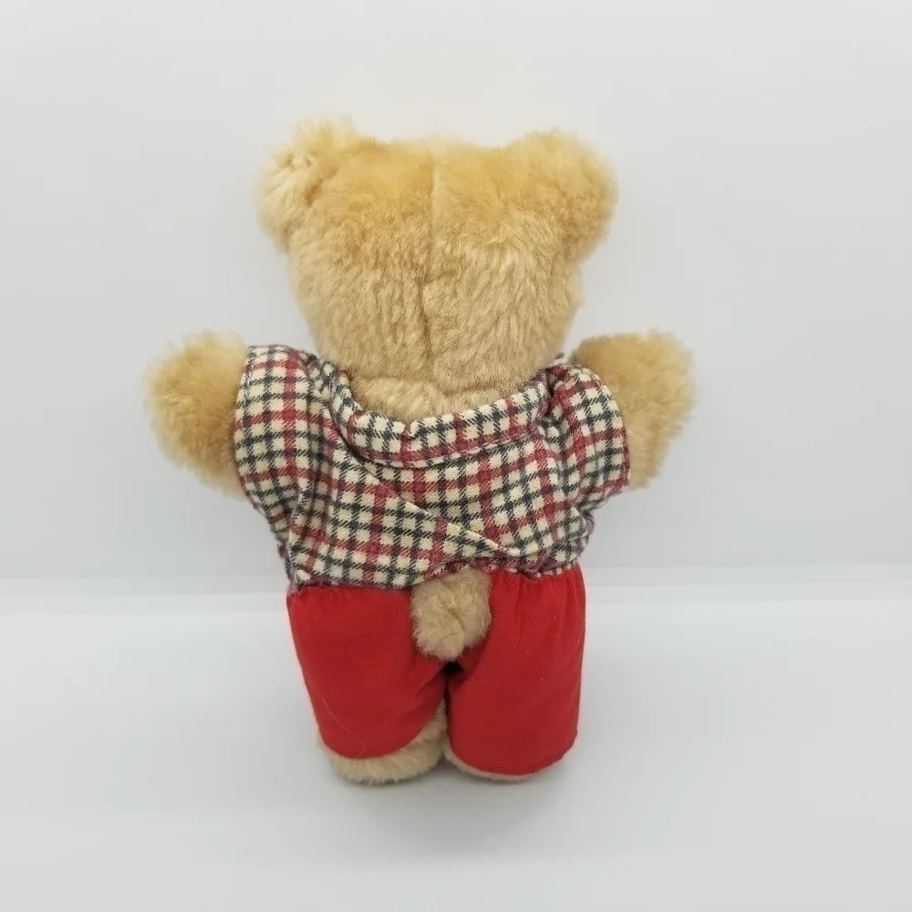 small teddy bear with plaid shirt and red shorts